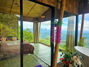 a bathroom with a tub and a large window at Mon Ngo misty haven B3 in Ban Nong Chaeng