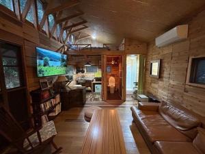 a living room with a couch and a table and a tv at NAT PARK Isumi RV in Iwada +27 photos