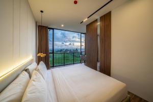 a bedroom with a bed and a large window at Horizon Cemagi 2BR with Ocean View in Cemagi