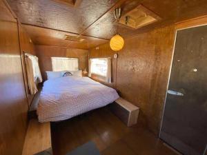 a bedroom in a tiny house with a bed at NAT PARK Isumi RV in Iwada