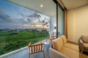a living room with a couch and a large window at Horizon Cemagi 2BR with Ocean View in Cemagi