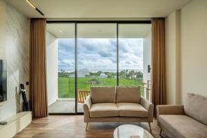 a living room with a couch and a large window at Horizon Cemagi 2BR with Ocean View in Cemagi
