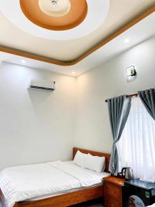 a bedroom with a bed with a coffered ceiling at Cali Hotel Tây Ninh in Tây Ninh