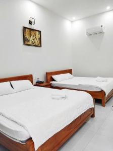 two beds sitting next to each other in a room at Cali Hotel Tây Ninh in Tây Ninh