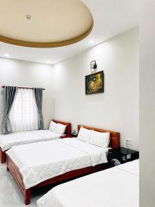 two beds in a room with white walls at Cali Hotel Tây Ninh in Tây Ninh +26 photos