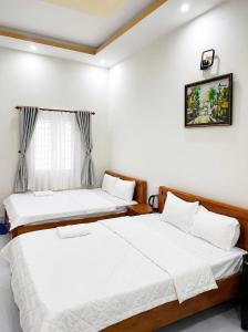 a bedroom with two beds and a window at Cali Hotel Tây Ninh in Tây Ninh