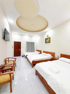 a room with four beds and a large ceiling at Cali Hotel Tây Ninh in Tây Ninh