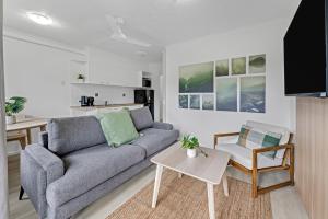a living room with a couch and a table at Mackay Seabreeze Apartments in Mackay