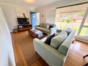 a living room with a couch and a tv at Horace Street 8 in Shoal Bay