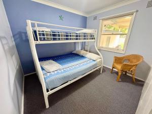 a bedroom with a bunk bed and a chair at Horace Street 8 in Shoal Bay