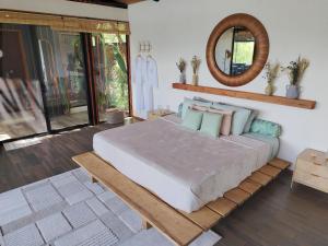 a bedroom with a large bed and a mirror at Cocolhu Treehouse & Ocean View in Tamarindo