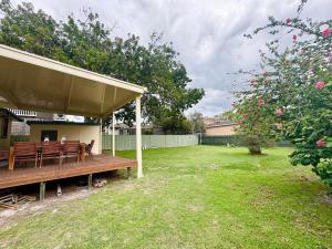 a porch with a wooden bench in a yard at Horace Street 8 in Shoal Bay