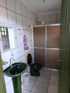 a bathroom with a green sink and a toilet at cantinho do descanso in Dourados