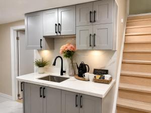 a kitchen with white cabinets and a sink at Vita House - Minutes to Rogers Stadium - Walk or Transit - Near VELD Downsview and Yorkdale in Toronto