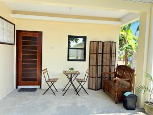 a patio with chairs and a table and a door at Lyric and Melody Collection in Santa Catalina