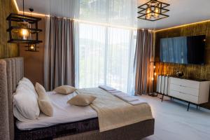 a bedroom with a large bed and a large window at Luxe 1 apartments in Obzor