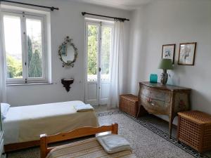 a bedroom with a bed and a table and windows at La Casina a Oleggio in Oleggio