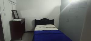 a small bedroom with a bed and a dresser at Casa Hotel La Unión in Santa Cruz de Mompox