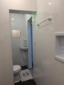a small bathroom with a toilet and a sink at Chalé Lunar in Arraial d'Ajuda