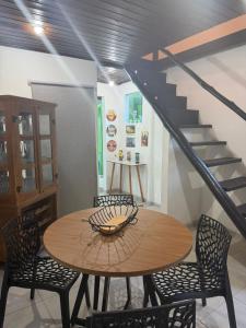 a dining room table with chairs and a staircase at Chalé Lunar in Arraial d'Ajuda