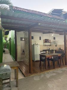 a patio with a wooden table and a kitchen at Chalé Lunar in Arraial d'Ajuda +8 photos