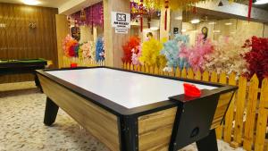 a ping pong table in a room with flowers at Spago Inn-Only for Families & Couples not for Bachelors in Mahabalipuram