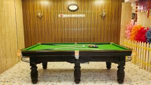 a pool table in front of a wall with a clock at Spago Inn-Only for Families & Couples not for Bachelors in Mahabalipuram +219 photos