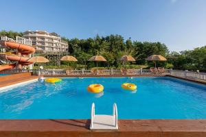 a large swimming pool with chairs and umbrellas at Taean Modern186 Pension in Taean
