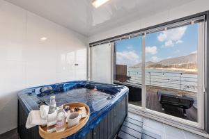a bath tub in a room with a large window at M129 Pension Namhae in Namhae