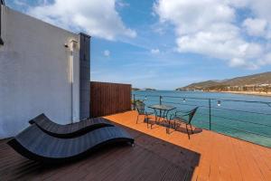 a bench on a deck with a view of the water at M129 Pension Namhae in Namhae