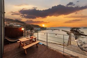 a table on a balcony with a view of the ocean at M129 Pension Namhae in Namhae