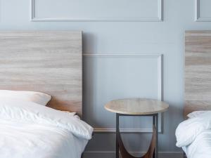 a bedroom with two beds and a small table between them at Yangyang Hotel Unbound House in Yangyang