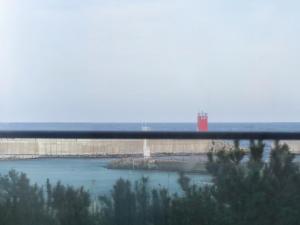 a bridge over a river with a lighthouse in the distance at Yangyang Hotel Unbound House in Yangyang