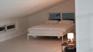 a white bedroom with a bed in a attic at Nonsan Yeoyurowa Pension in Nonsan