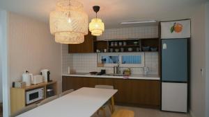 a kitchen with a white table and a refrigerator at Nonsan Yeoyurowa Pension in Nonsan