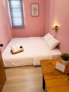 a bedroom with a white bed in a pink wall at Hostel In The City in Pom Prap