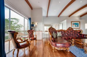 a living room with leather furniture and a table at Maleny Terrace Cottages in Maleny +164 photos