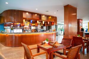 a restaurant with wooden tables and a bar at Elite Suites Patong in Patong Beach