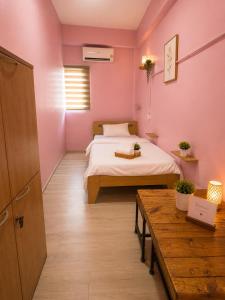a small room with a bed and a table at Hostel In The City in Pom Prap +6 photos
