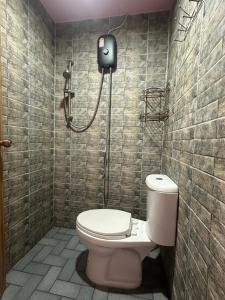 a bathroom with a toilet and a shower at Hostel In The City in Pom Prap