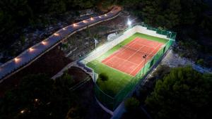 Eine Luftaufnahme eines Tennisplatzes bei Nacht in der Unterkunft Villa Amara Private Estate in Anafonítria