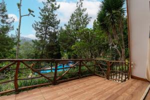 a balcony with a view of a pool and trees at Barusen Hills By BHATARA in Gambung