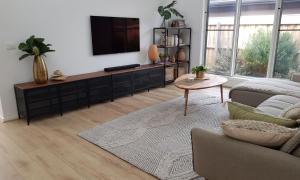 a living room with a tv and a couch and a table at Adagio at Lonsdale in Point Lonsdale