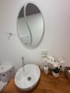 a bathroom with a white sink and a mirror at Cabañas Agroturistica la Polkca - Experiencia Cafetera in Líbano +13 photos