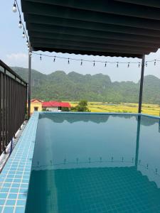 a swimming pool with a view of the mountains at Hidden Green Hotel Tam Coc in Vũ Lâm