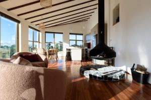 a living room with a couch and a fireplace at The Hemp House | Table Cape Ocean Views in Table Cape