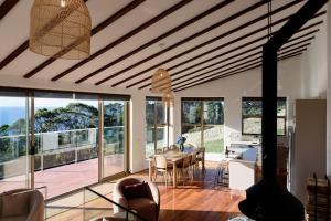 a living room with a wooden ceiling and a table and chairs at The Hemp House | Table Cape Ocean Views in Table Cape