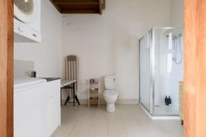 a white bathroom with a toilet and a shower at The Hemp House | Table Cape Ocean Views in Table Cape +36 photos