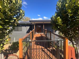 a house with a wooden staircase leading to the front door at Among The Trees Guest Suite in Kooralbyn