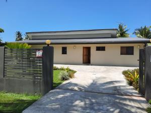 a white house with a fence and a driveway at Haven Retreat in Pacific Harbour